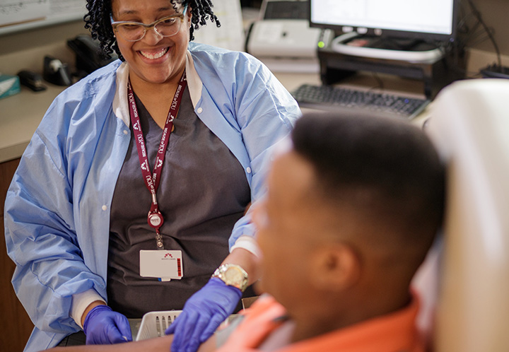 A nurse with a smile engages in conversation with a patient, displaying warmth and compassion.
