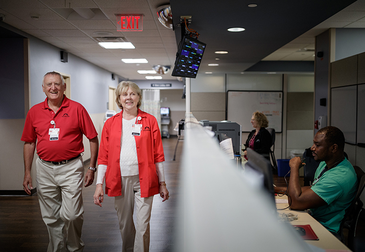 Older male and female wearing read shirts in hospital